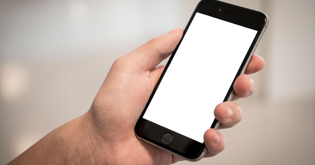 A hand holding a modern smartphone with a blank screen, ideal for design mockups.